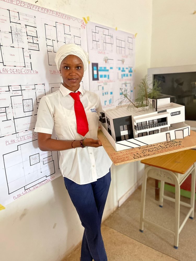 Une étudiante tient une maquette de bâtiment moderne
