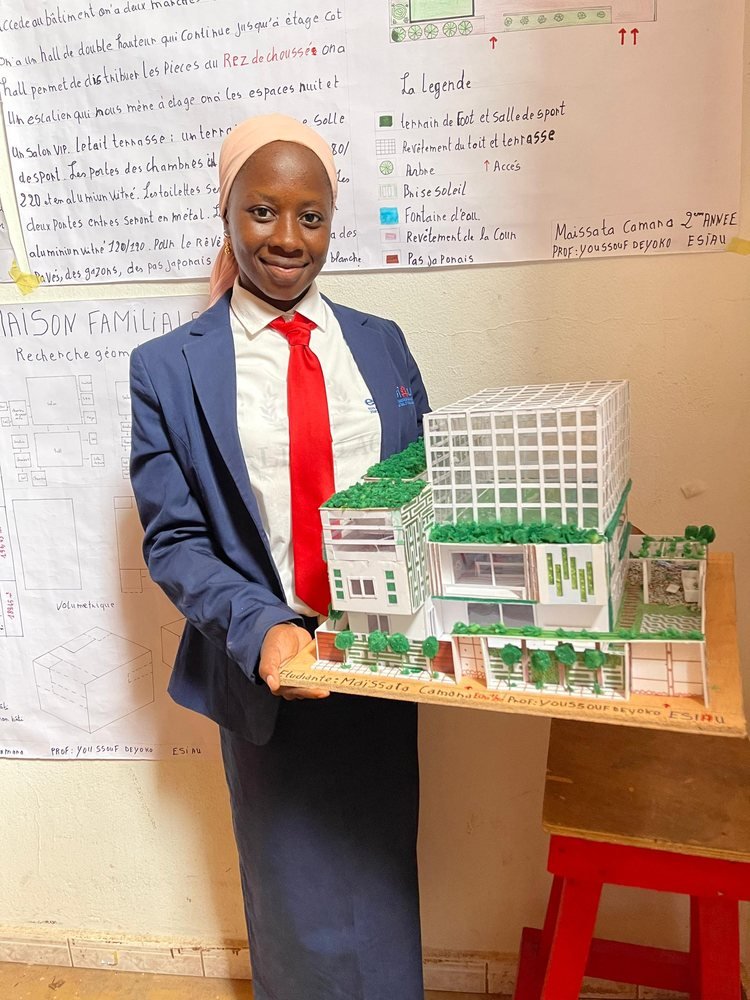Une étudiante tient la maquette d'un immeuble végétalisé