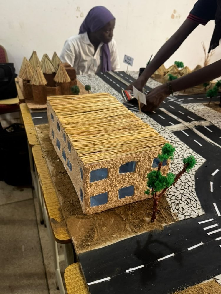 Maquette d'un bâtiment couvert de paille au bord d'une route